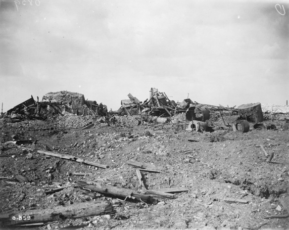Photographie noir et blanc d’un bâtiment industriel en ruines dans un paysage dévasté.