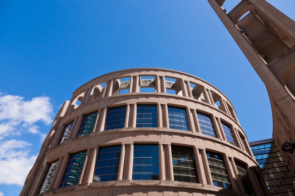 Photo couleur d’un immeuble rond ressemblant au Colisée de Rome, mais dont les fenêtres en verre aux deux étages supérieurs le placent fermement dans l’époque contemporaine.